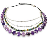 A multi-strand beaded necklace featuring faceted purple amethyst beads, green and brown jasper beads, silver chain links, and a black elastic cord with a silver clasp, shown on a white background.