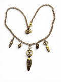 A vintage-style bronze chain necklace with multiple dangling charms, including a central pendant with engraved details, displayed on a clean white background.