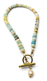A beaded necklace featuring light green, blue, and yellow amazonite beads with a gold toggle clasp and a dangling white pearl, shown on a white background.