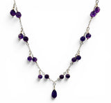 Necklace with purple beads on a white background. Amethyst Drop Statement Necklace.