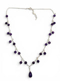 Necklace with purple beads and a teardrop-shaped pendant on a white background