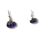 Pair of purple beaded earrings on a white background