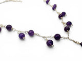 Necklace with purple beads on a white background. Amethyst statement necklace close up .