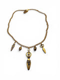 An antique-style gold-toned chain necklace with multiple dangling charms, including a prominent owl pendant, photographed on a plain white background.