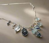 Necklace with various charms and beads on a beige background