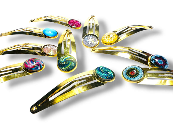 Gold hair clips with colorful gemstones on a white background