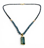 Necklace with blue beads and a rectangular pendant on a white background
