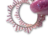 Close-up of pink beaded hoop earrings 