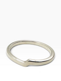 A minimalist silver ring with a unique, slightly wavy or stepped profile, photographed on a clean white background.