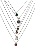 Five layered silver necklaces with different colored gemstone pendants, arranged in a cascading V-shape on a plain white background.