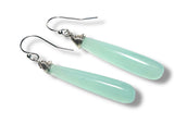 Pair of light blue teardrop earrings with silver wire wrapping on a white background