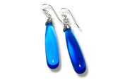 Blue teardrop earrings with silver hooks on a white background