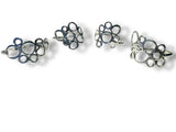 Set of four silver and blue floral earrings on a white background
