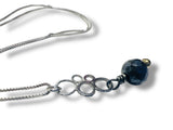 Necklace with a blue bead and silver chain on a white background