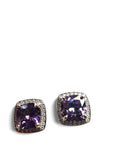 A pair of square stud earrings featuring cushion-cut purple gemstones surrounded by a halo of small clear stones in a silver-tone setting, shown on a plain white background.