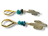 Gold cactus-shaped earrings with turquoise beads on a white background