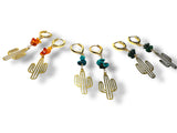 Set of gold cactus-shaped keychains with colorful beads on a white background