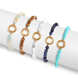 beaded bracelets with gold circular accents on a white surface