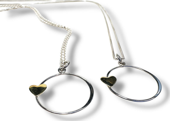 Two silver necklaces with heart-shaped pendants on a white background