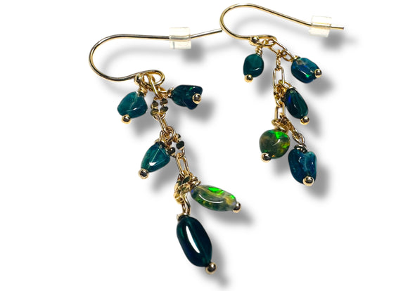 Gold earrings with green gemstones on a white background