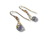 Gold earrings with clear gemstones on a white background
