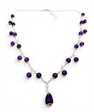 Purple beaded necklace with a teardrop pendant on a white background