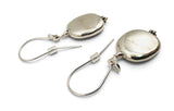 A pair of silver drop earrings with polished oval pendants and fishhook ear wires, shown on a plain white background.