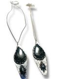 Two silver necklaces with black stone pendants on a white background