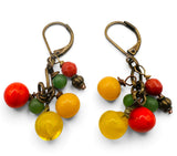A pair of dangling earrings with antique bronze leverback hooks and clusters of glossy beads in red, yellow, and green on a white background.