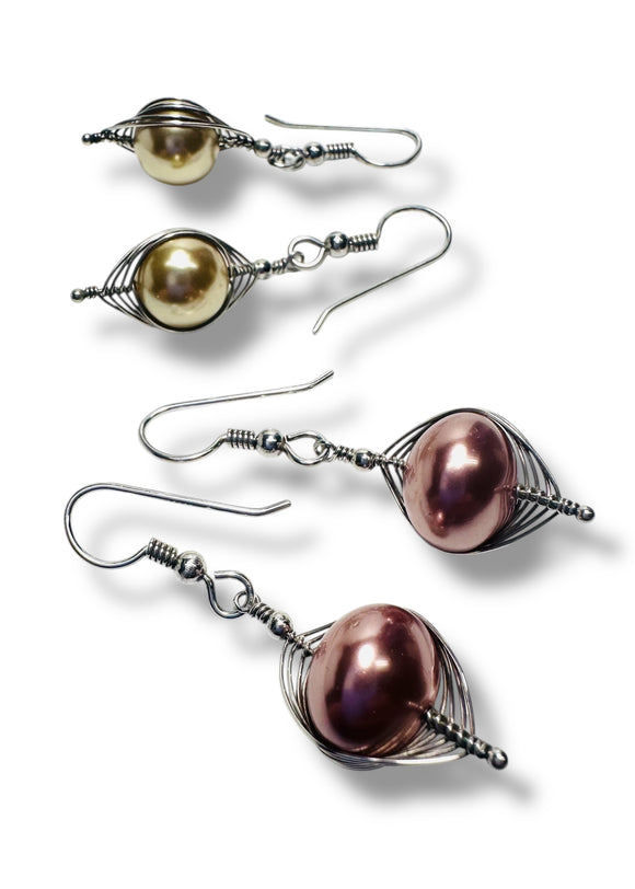 Two pairs of glass pearl earrings waisted in a pattern with silver wire. 