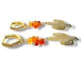 Gold earrings with cactus design and orange beads on a white background