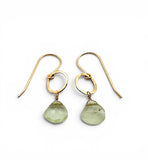 Gold earrings with green teardrop-shaped stones on a white background