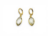 Gold earrings with teardrop-shaped clear stones on a white background