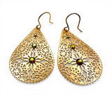 Gold filigree earrings with green gemstones on a white background