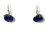 Purple pumpkin-shaped earrings with gold accents on a white background