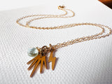 Necklace with gold charms on a white fabric background