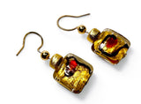 Gold and red glass earrings on a white background