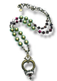 Necklace with green beads and a decorative clasp on a white background