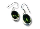 Green peridot gemstone earrings with silver hooks on a white background