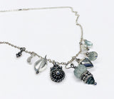 Necklace with various charms and beads on a white background