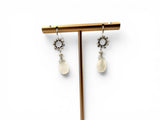 Pair of earrings with white stones on a gold stand against a white background. Howlite Earrings 