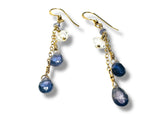 Pair of gold earrings with blue and clear gemstones on a white. background Iolite and Herkimer Cascade Earrings
