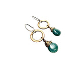 Copper hoop earrings with green gemstones on a white background