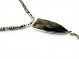 Necklace with a large, faceted pendant on a white background