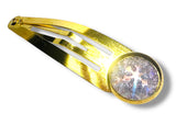 Gold hair clip with a round, faceted gemstone on a white background
