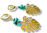 Gold leaf earrings with turquoise stones on a white background