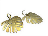 Gold leaf-shaped Earrings on a white background. Monstera Leaf Hoop Earrings.
