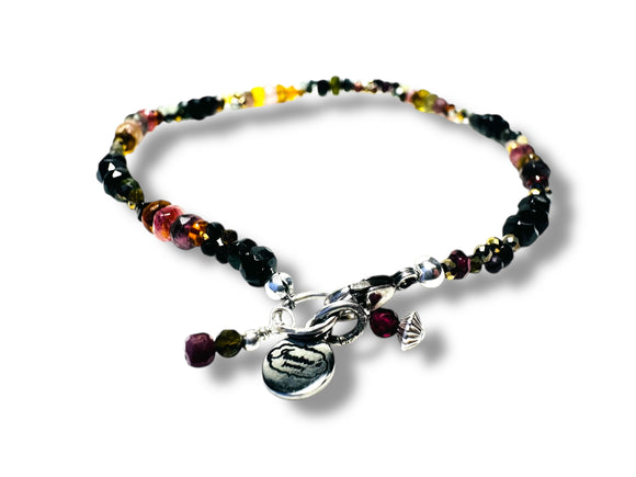 Multicolored Tourmaline beaded bracelet with charms on a white background