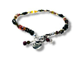 Multicolored Tourmaline beaded bracelet with charms on a white background