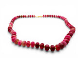 Necklace with pink and red beads on a white background